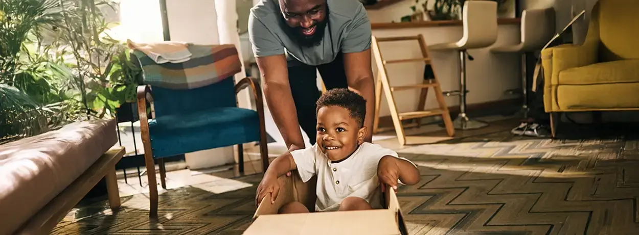Dad pushing boy in a box
